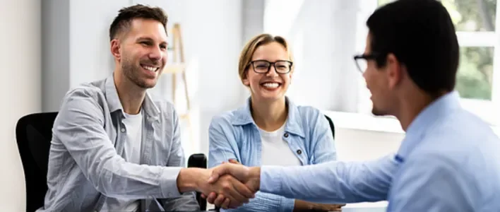 men shaking hands across table