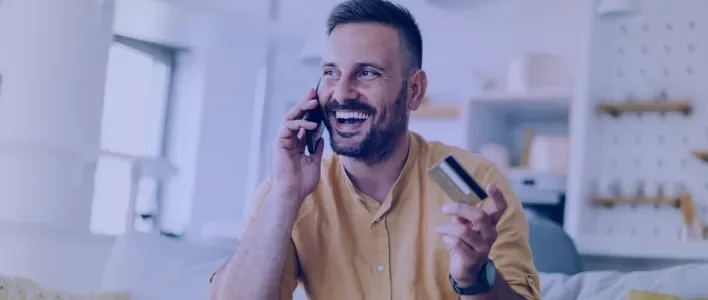 man_smiling_holding_a_credit_card