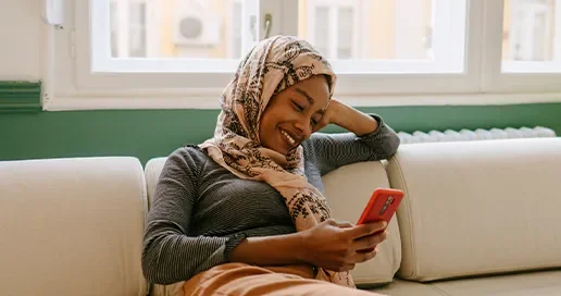A woman sat down, smiling at her phone
